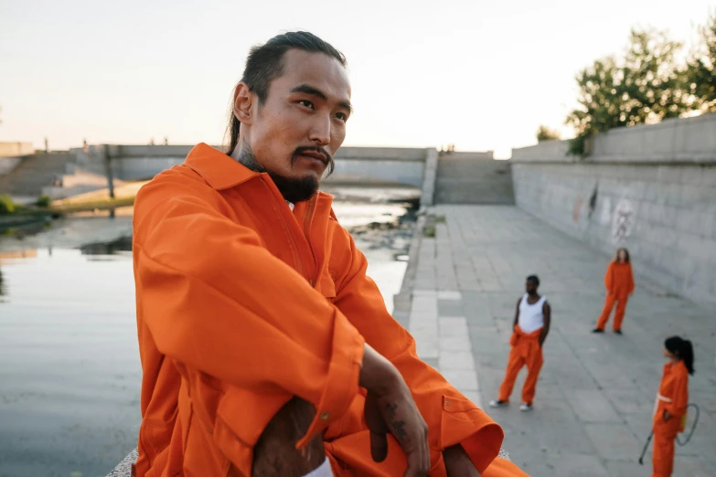 two guys in orange prison uniforms standing together