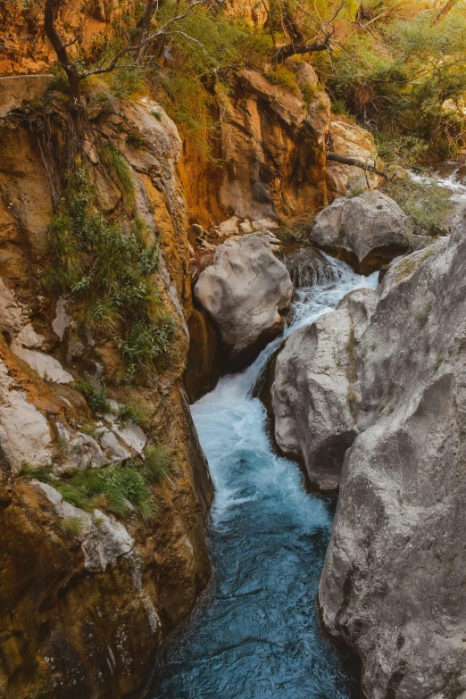 a very small stream flowing through some big rocks