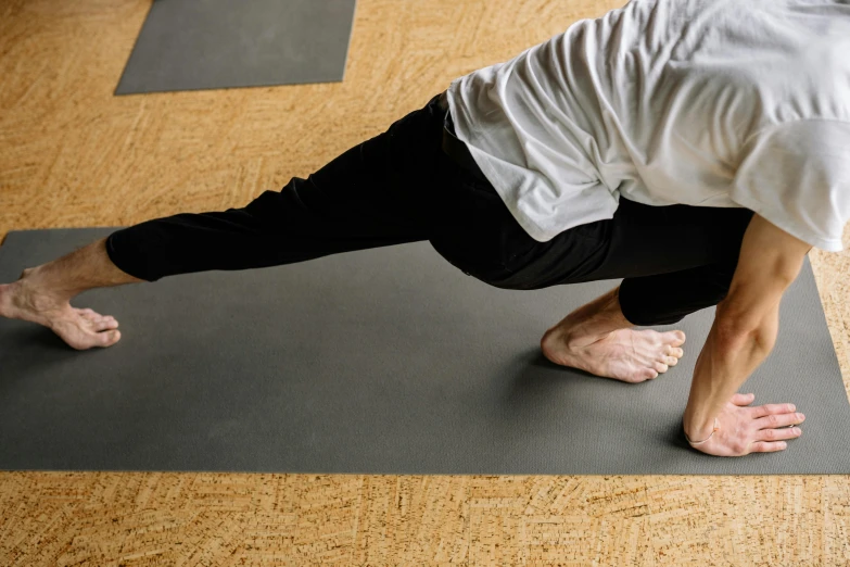 a man performing a yoga pose on top of a mat