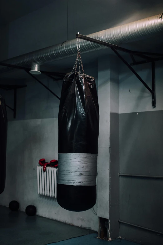a black boxing bag hanging from a ceiling