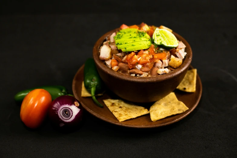 a bowl of beans and tortilla chips sitting on a plate