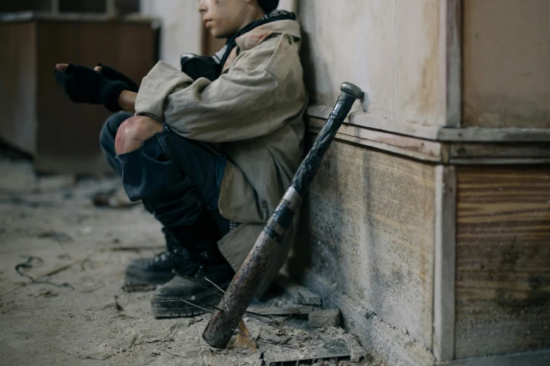 a boy is sitting in a doorway on the floor