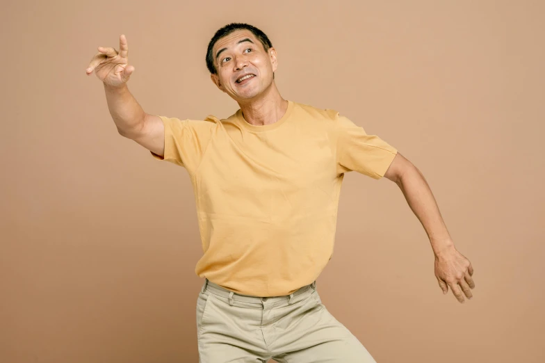 an asian man is holding his fingers up and smiling