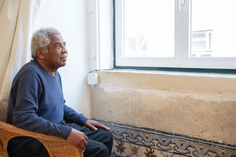 a man with grey hair is sitting by the window