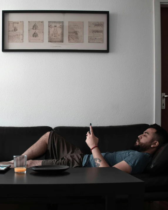 a man laying on a couch with his hand in the air