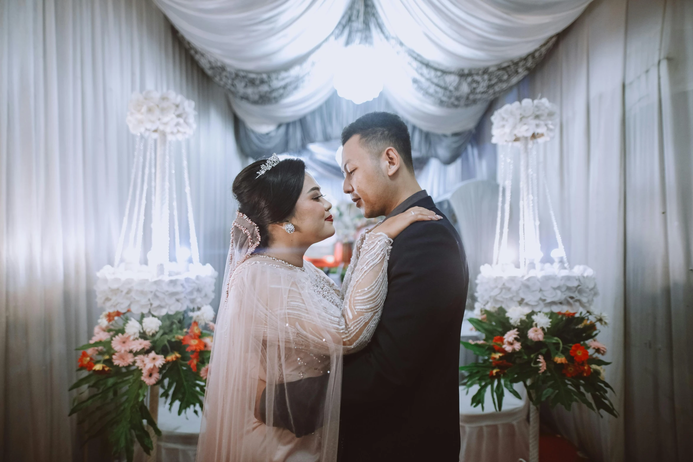 a bride and groom standing in front of a floral decoration