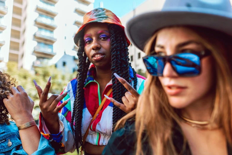 two ladies with different colors and styles holding peace signs