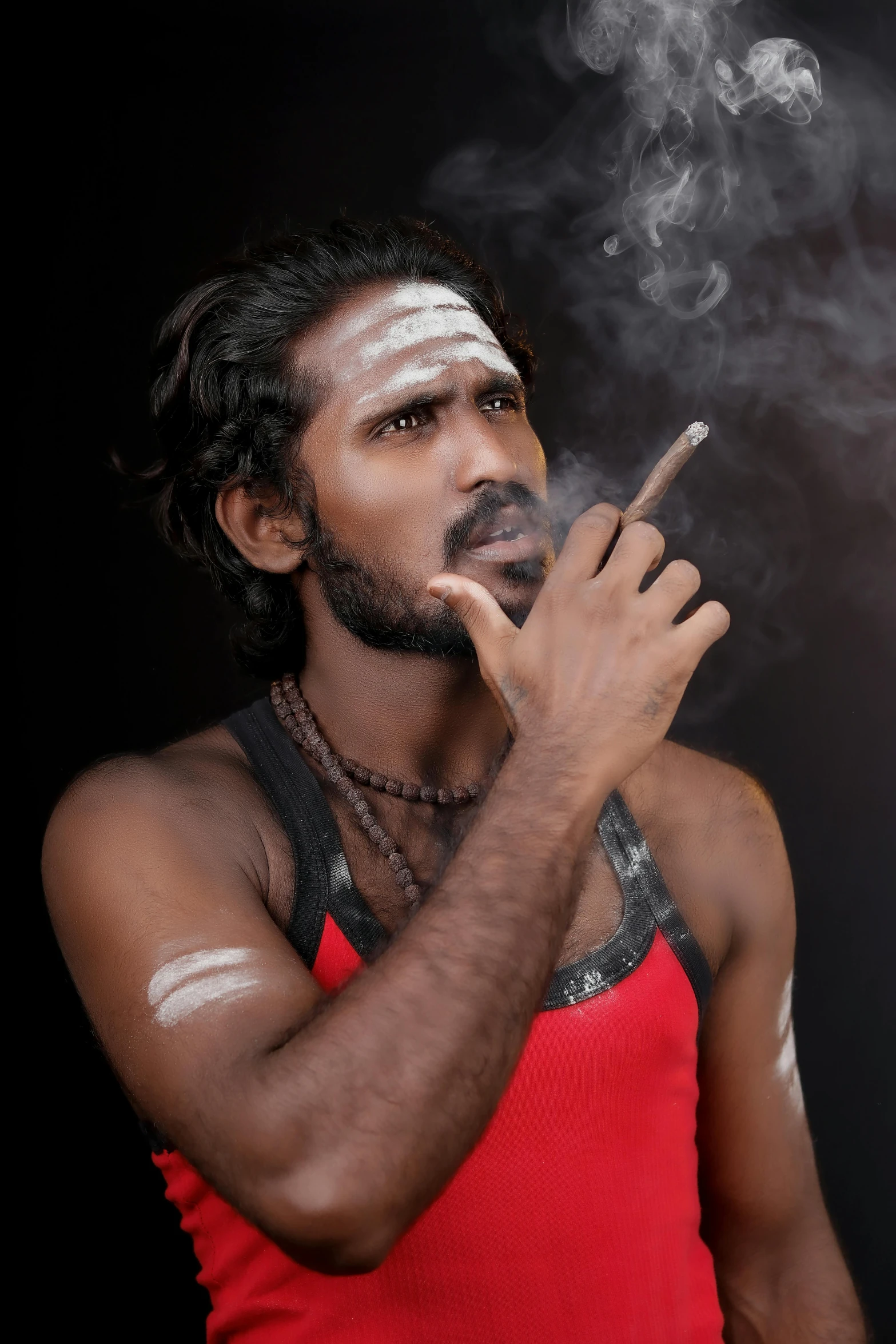 a man smoking a cigarette in the dark