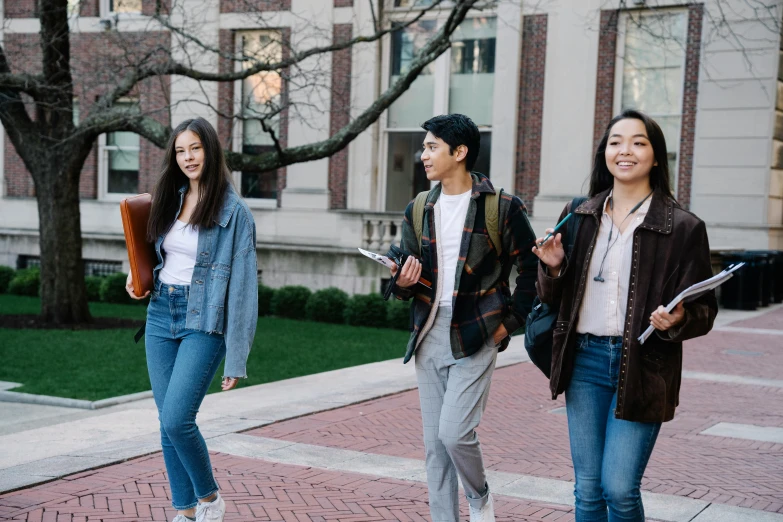 three young women and one man are walking together