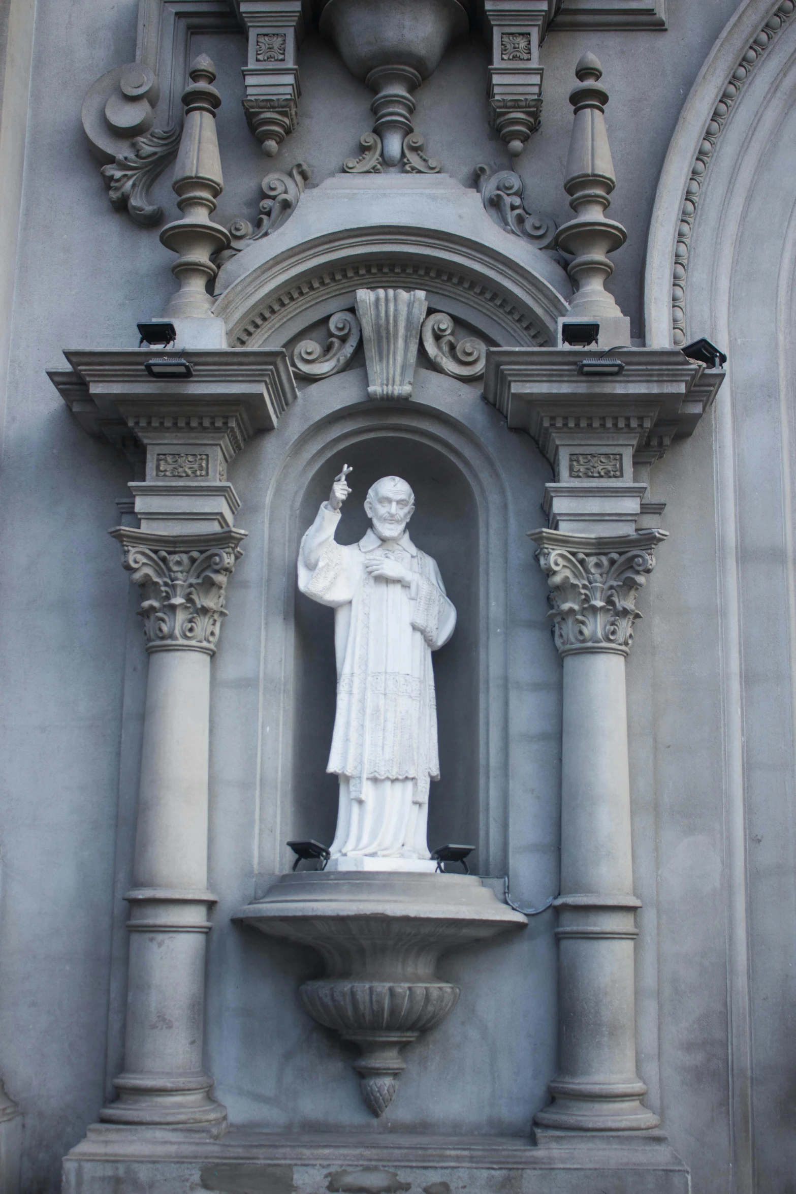 a statue of a priest next to a building