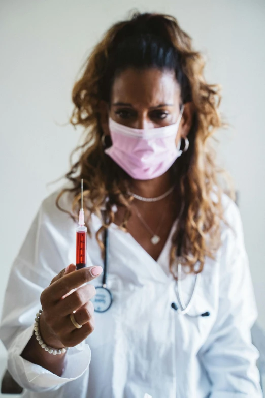 woman with medical equipment holding sys in front of her face