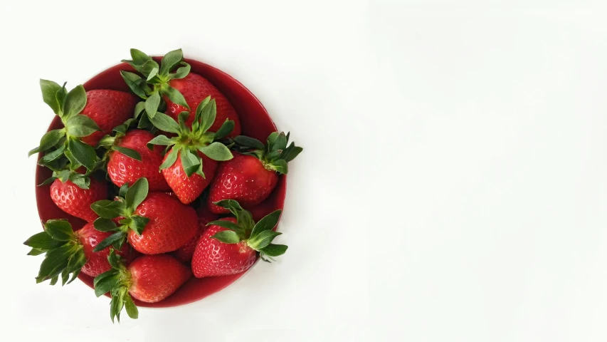 a small group of strawberries that are in a bowl