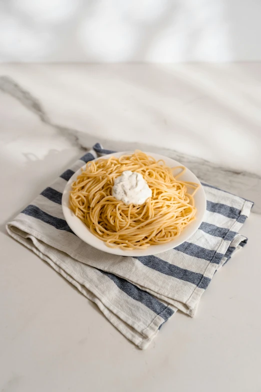 the plate of spaghetti is sitting on a towel