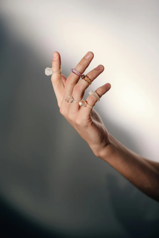 an outstretched hand with three rings attached