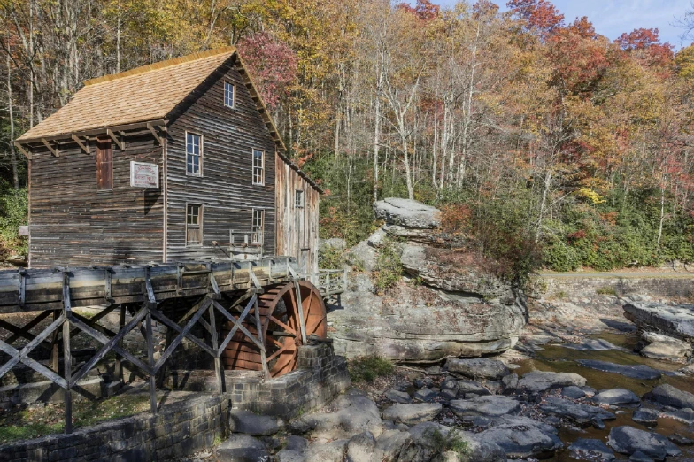 a old mill sitting next to a creek