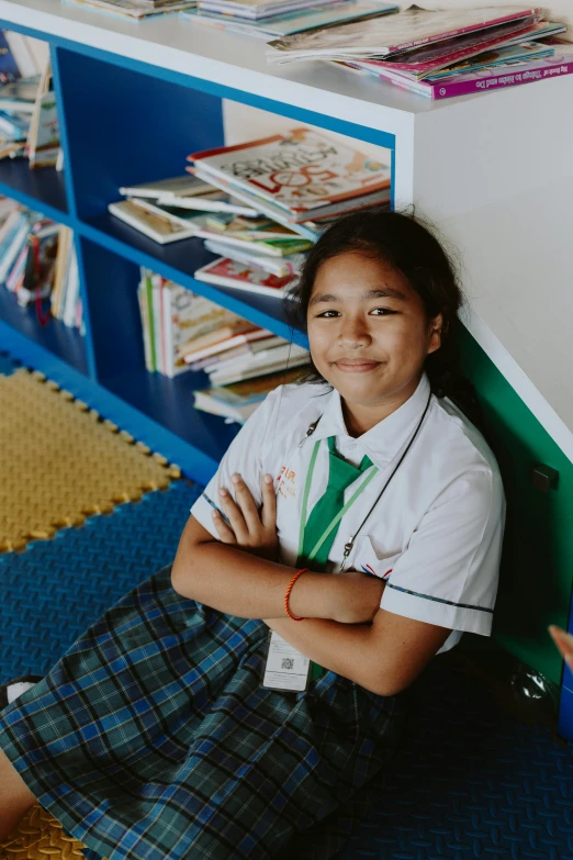 a girl sits smiling while she wears a green neck tie