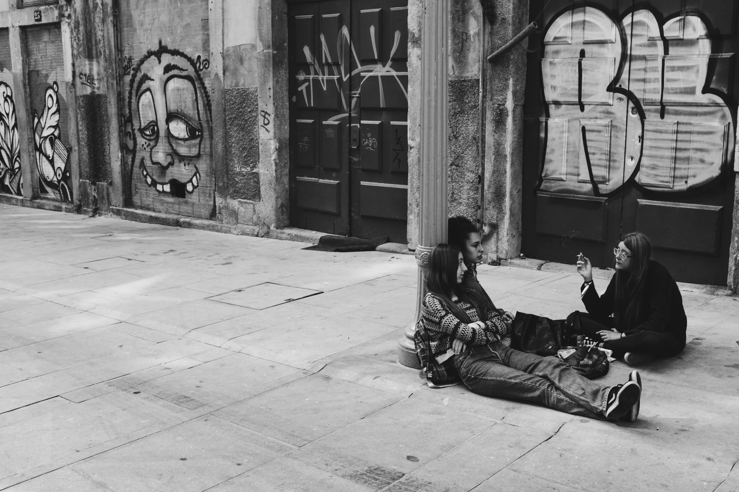 two people sitting on the ground, talking