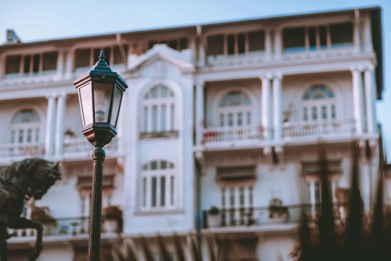 an old - fashioned street light with the building in the background