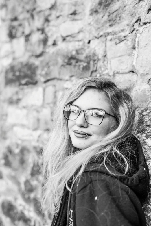 black and white portrait of woman in front of stone wall