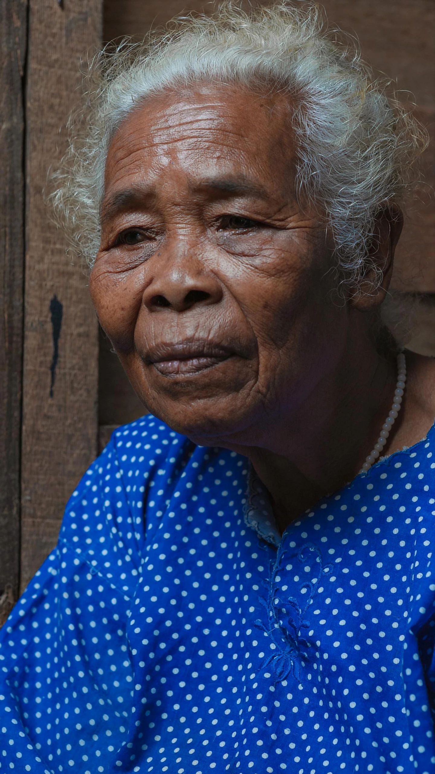 a woman who has shaved white hair in a blue shirt