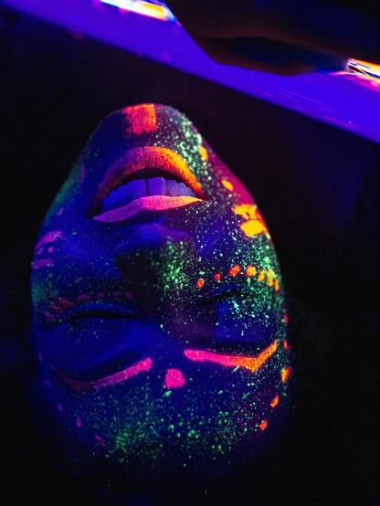 a dark mask with colorful paint on it