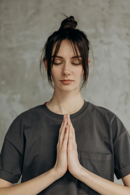 a young woman standing in a yoga pose with her eyes closed