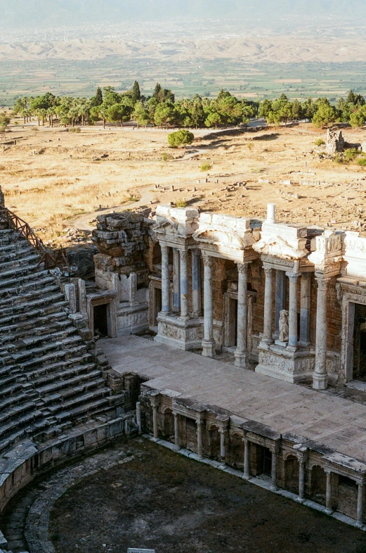 an aerial view of a ruined building in the middle of a desert area