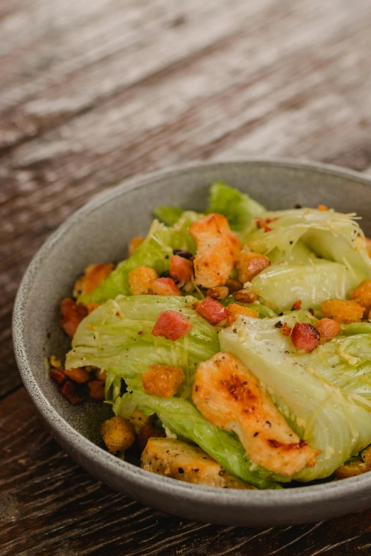 a bowl of chicken and lettuce salad on a table