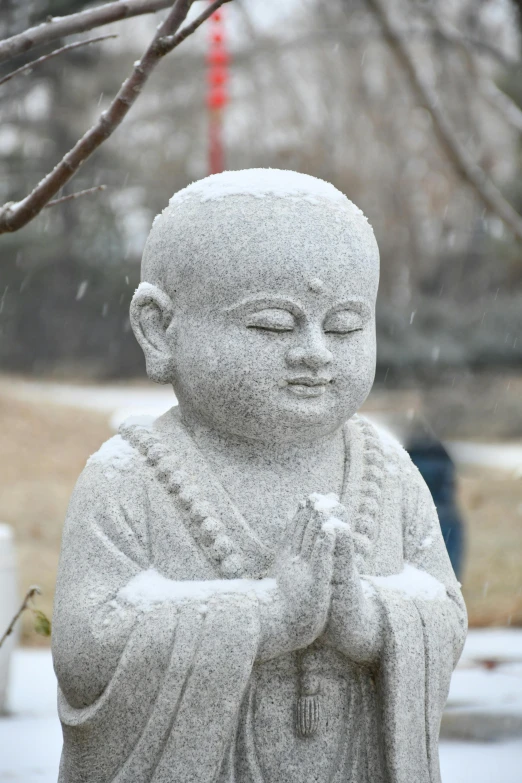 an older statue of a buddha in the snow