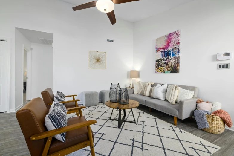 a living room with white walls and gray couches