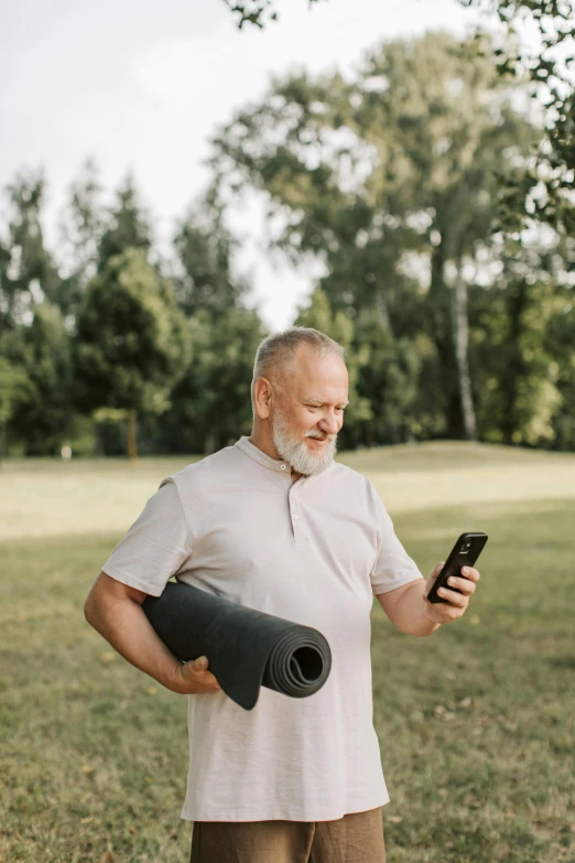 a man in a white shirt holding a cellphone