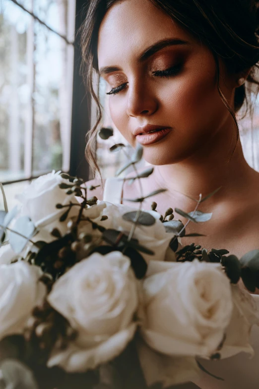 a woman holding a bouquet of white flowers