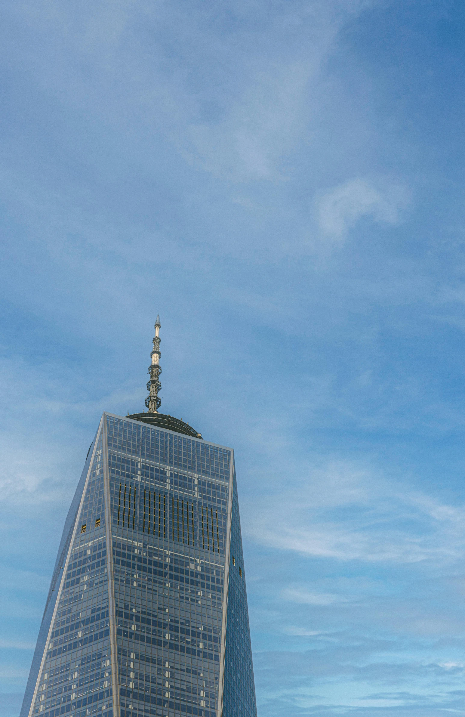 an airplane flying above a tall building in the sky