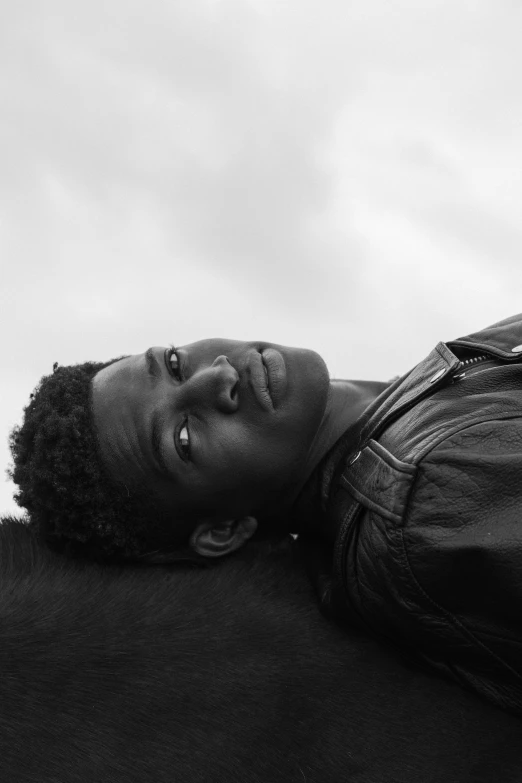 black and white image of a male laying on the ground