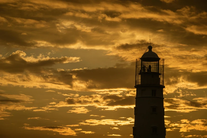 a clock tower silhouetted by the sunset clouds