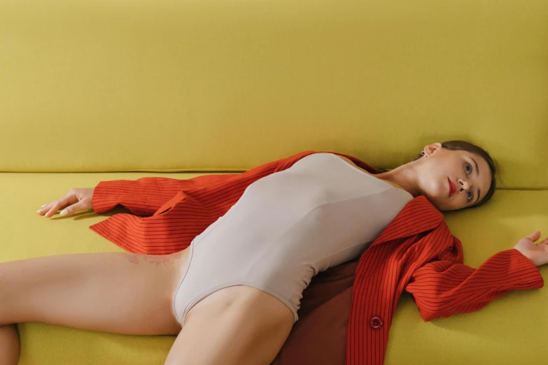 woman in white top laying on a yellow couch