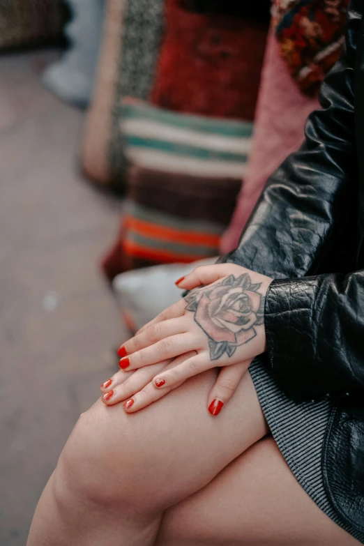 a woman sitting on top of a bench wearing tattoos