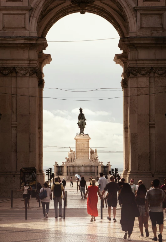 many people are walking around under an arch