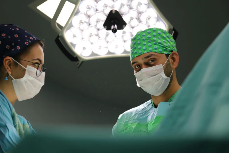 two doctors stand next to each other in front of a bright, spotlight light