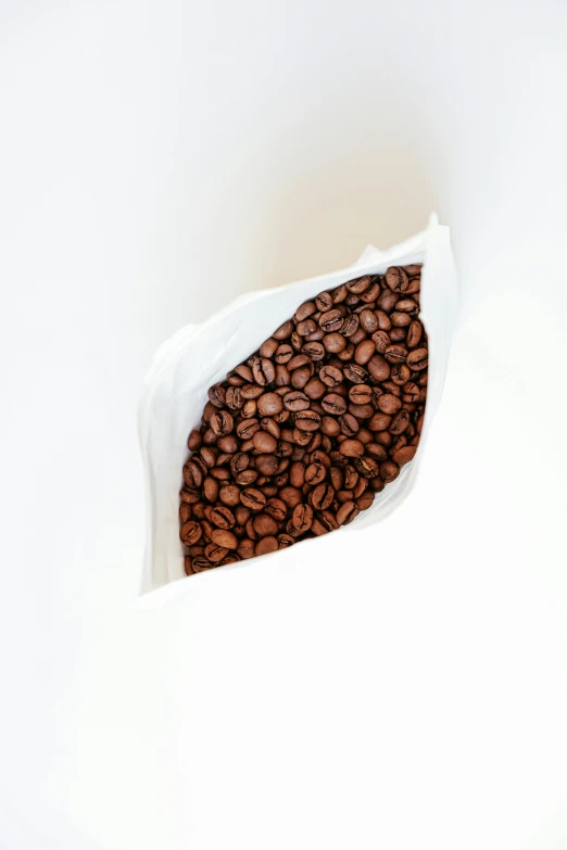 a white bag filled with coffee beans on top of a table