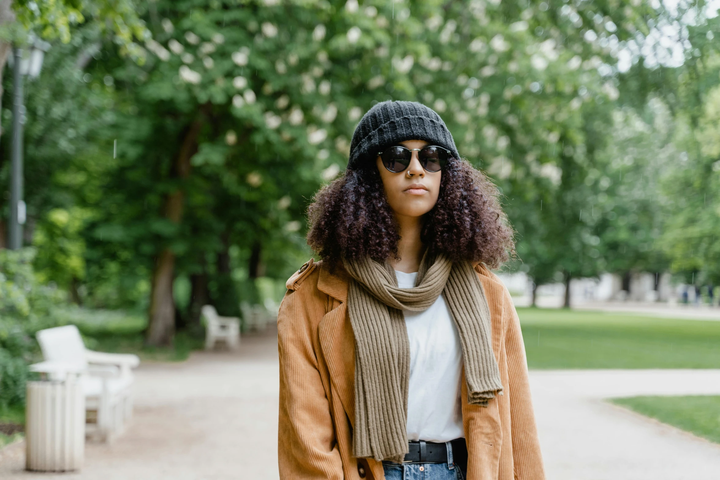 a young woman in jeans and scarf on a sidewalk