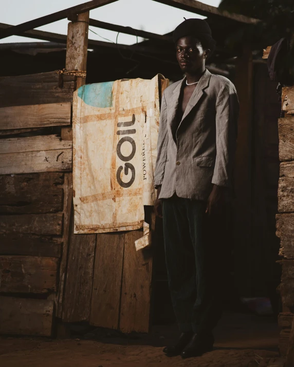 a man in a suit standing next to a wooden shed