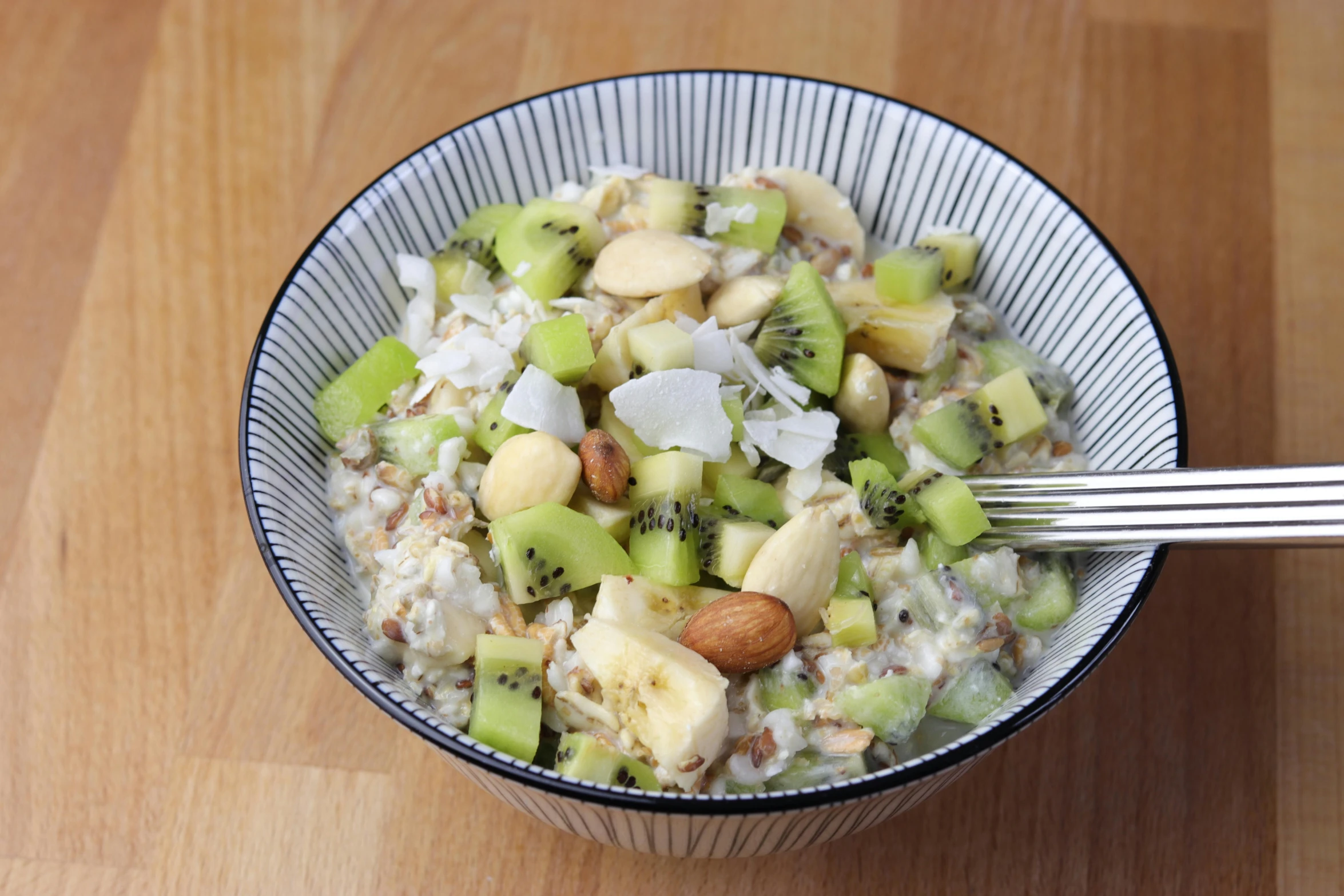 the plate contains rice, kiwi, nuts and cheese