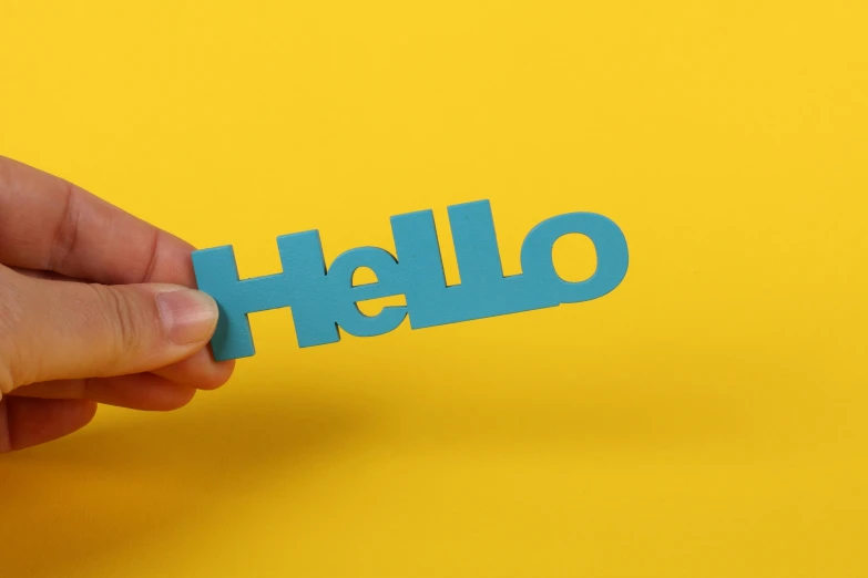 a man hand holding a cut out piece of paper with the word hello