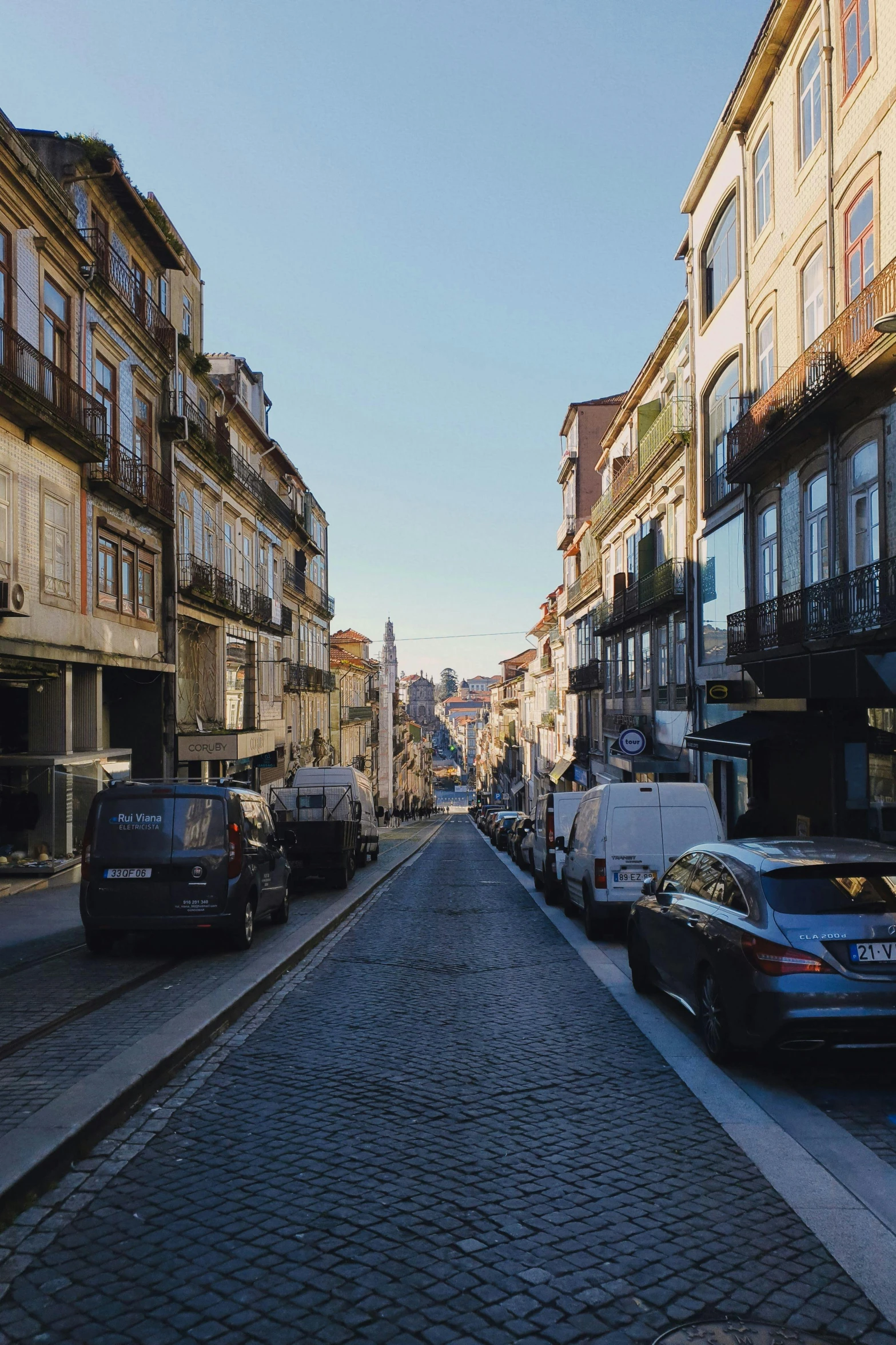 a wide brick road in front of some very tall buildings