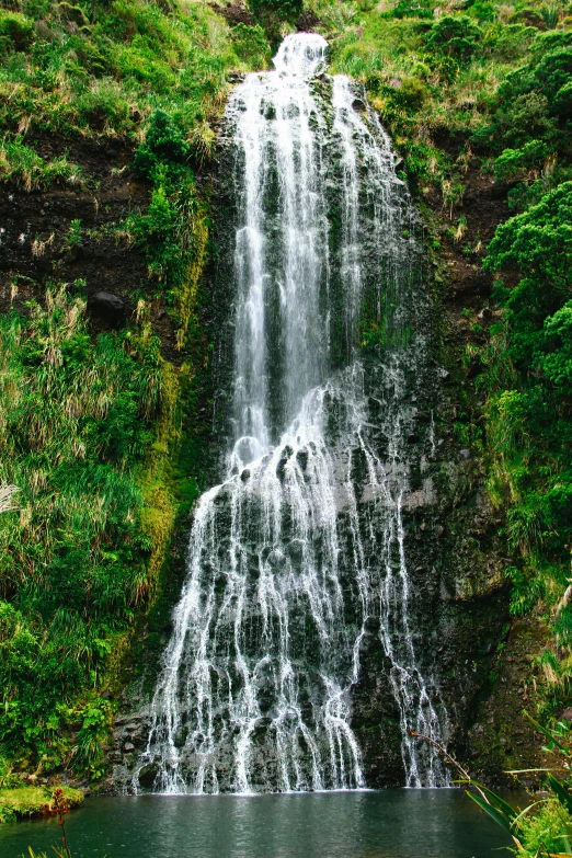 a waterfall flowing from the ground into a body of water