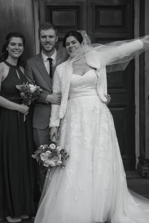 a couple dressed in wedding clothes holding hands outside