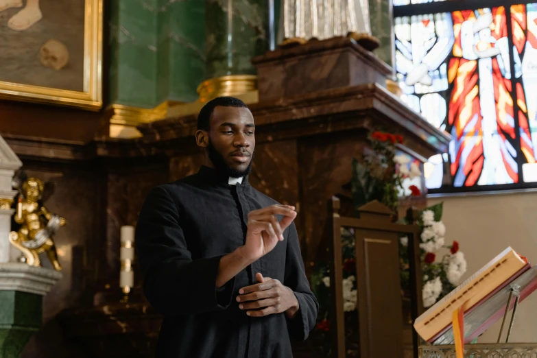 a priest is in his church next to a sheet