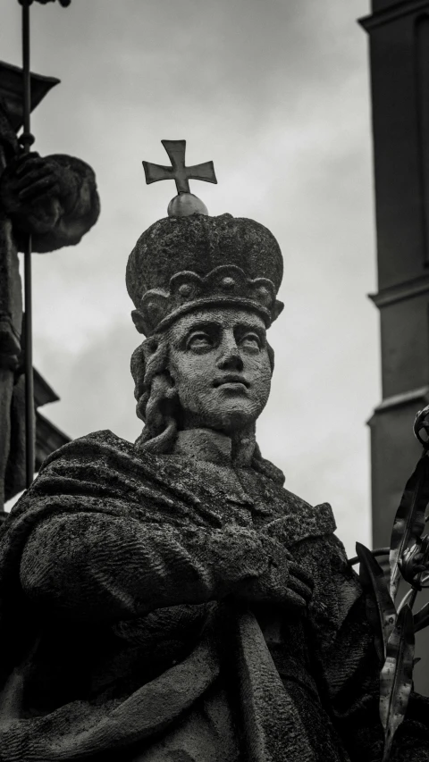 an antique statue and a cross on the top