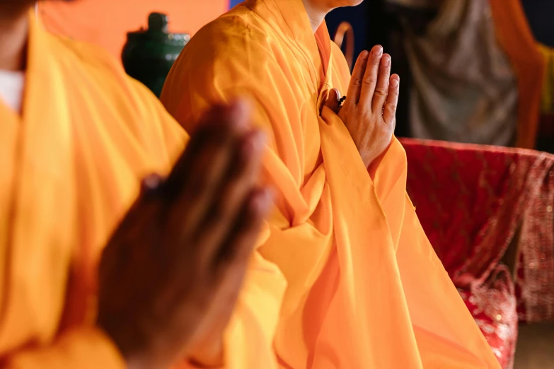 the monks are wearing orange robes together